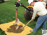 Auguring a hole in the earth for a foundation repair in Wilmington Manor