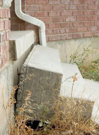 sinking outdoor concrete steps showing cracking and soil washout in Harrington