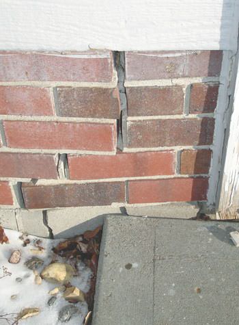 Severe street creep damage to a garage wall outside a Long Neck home