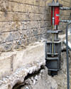A completed installation of foundation push piers lifting a foundation in Elsmere